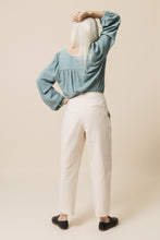 Load image into Gallery viewer, Back view of lady wearing tapered Mitchell Trousers, with hand on hip