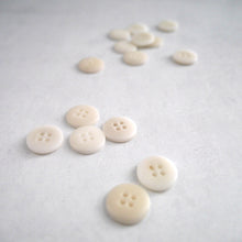 Load image into Gallery viewer, 4-hole buttons strewn across surface.