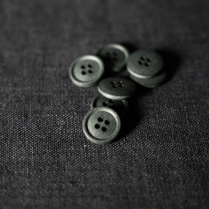 Pile of 4-Hole Cotton Buttons on top of fabric