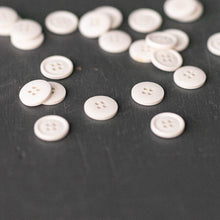 Load image into Gallery viewer, A handful of Cotton Buttons sprinkled on table top.