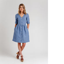 Load image into Gallery viewer, Lady stands wearing V-neck, knee-length, buttoned down dress with elbow length elasticated cuffs