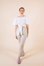 Load image into Gallery viewer, Front view of cropped top with puff sleeves with waist ties tied at front