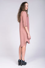 Load image into Gallery viewer, Side view of lady wearing tunic style dress in pink fabric. Hem falls slightly longer at back.