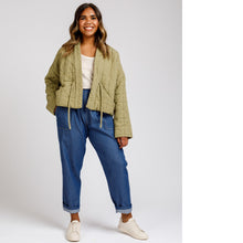 Load image into Gallery viewer, Lady stands wearing a quilted Hovea Jacket with loose ties are centre front