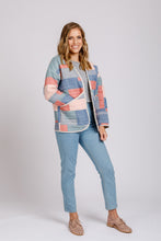 Load image into Gallery viewer, Lady wears quilted Hovea Jacket with bound edges, and rounded bottom corners, hip length.