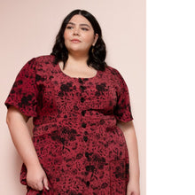Load image into Gallery viewer, Lady wears Hughes Dress with scoop neckline, buttons down along centre front, in a floral print fabric.
