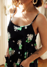 Load image into Gallery viewer, Lady wears Paola Dress, a round scoop neckline with straps, hands in pockets on front of dress