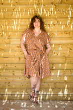Load image into Gallery viewer, Lady stands against wall wearing Byzance Dress, v-neck, cap sleeves, knee length, elasticated waist line
