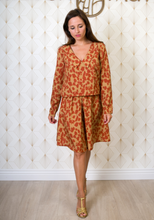 Load image into Gallery viewer, Lady wears Faye Dress variation, knee length with flat collar in a busy print fabric