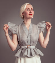 Load image into Gallery viewer, Lady wears striped blouse with frilly peplum from waist, holding puffy sleeves from armhole.