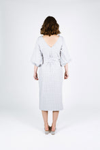 Load image into Gallery viewer, Back view shows lady in back V-neckline, waist tie, below knee length dress with balloon sleeves