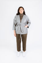 Load image into Gallery viewer, Lady wears Juno Jacket over a polo sweat. Jacket tied at waist, left hand in left front pocket