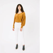 Load image into Gallery viewer, Lady wears Nexus Blouse, a V-neck button front, gathered sleeves into a cuff