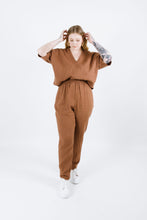 Load image into Gallery viewer, Lady wears variation one of the Pinnacle Top. Deep V neckline, elbow length sleeves. Tucked into trousers