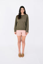 Load image into Gallery viewer, Lady wears variation three of the Pinnacle Top, a long sleeved sweatshirt with neck band and cuffs