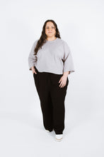 Load image into Gallery viewer, Lady wears variation two of the Pinnacle Top with round neckline and loose wrist length sleeves