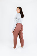 Load image into Gallery viewer, Back view of lady wearing Solar Tee with ruffles over long sleeves