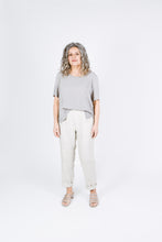 Load image into Gallery viewer, Lady wears Tide Top as a tee tucked into trousers