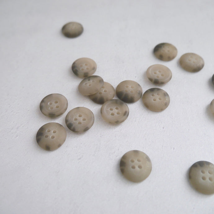 Buttons with four holes, scattered across worktop