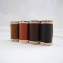 Load image into Gallery viewer, Four wooden reels of organic cotton sewing thread in Acorn Brown, Copper, Mid Brown and Dark Brown colours