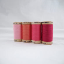 Load image into Gallery viewer, Four reels of organic cotton sewing thread in Carnation Pink, Salmon, Bubblegum and Fuchsia colours