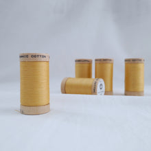 Load image into Gallery viewer, Five reels of Scanfil Organic Cotton Thread in Straw, a light mustard colour.