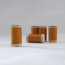 Load image into Gallery viewer, Five wooden reels of organic sewing cotton thread in a gold ochre colour