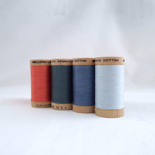 Load image into Gallery viewer, Four wooden reels of Scanfil Organic Cotton Thread in Salmon, Stormy Blue, Dusk, Ice colours.