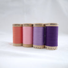Load image into Gallery viewer, Four wooden reels of Scanfil Organic Cotton Thread in Salmon, Carnation Pink, Lavender and Purple colours.
