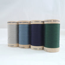 Load image into Gallery viewer, Four wooden reels of organic sewing cotton. Sand, Stormy Blue, Midnight, Forest.