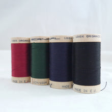 Load image into Gallery viewer, Four wooden reels of organic cotton sewing thread in wine red, forest green, navy and black.