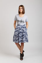 Load image into Gallery viewer, Front view of knee-length culottes in patttern fabric, posing with hands in pockets