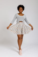 Load image into Gallery viewer, Lady wears above-knee length Tania Culottes in pattern fabric, holding out flares of culottes