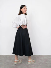 Load image into Gallery viewer, Side view of lady wearing the V-neck Cuff Top shows voluminous sleeves