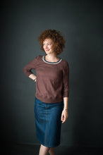 Load image into Gallery viewer, Lady stands wearing a knee length pencil denim skirt. Worn with a brown sweater.