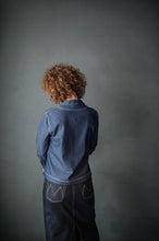 Load image into Gallery viewer, Back view of lady wearing denim shirt and denim skirt, highlights contrasting topstitching on skirt pockets at hip level.