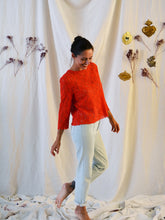 Load image into Gallery viewer, Front view of lady standing wearing long sleeve orange lace top.