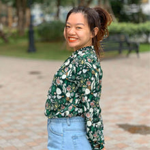 Load image into Gallery viewer, Side view of lady wearing Sille Shirt in a floral fabric print, long sleeves, worn tucked into jeans