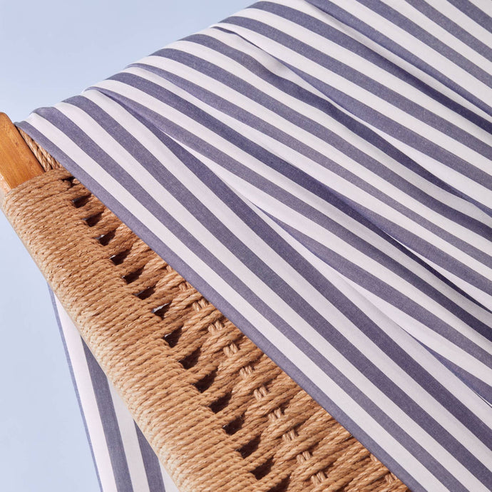 Close-up of stripey Viscose Modal fabric hangs over wicker chair