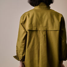 Load image into Gallery viewer, Back view of model wearing a pleated yoke shirt, made with Oxford Cotton Fabric
