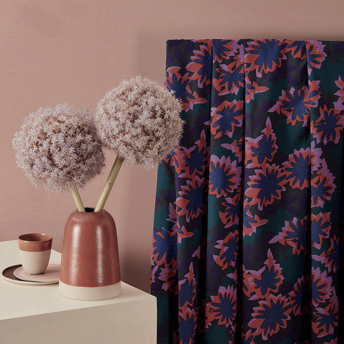 Abstract waterlily print on viscose fabric hangs by a table with vase