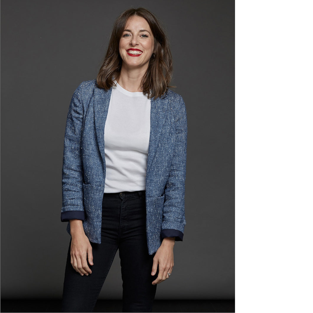 Lady wears an open blazer over a plain tee with sleeves folded up