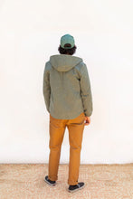 Load image into Gallery viewer, Back view of model wearing hooded Beachcomber jacket, with slight curved hem
