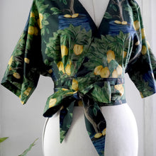 Load image into Gallery viewer, Close up of Elodie Wrap Top (on mannequin) with pleats at waistband, tied up with bow, made up of Citrus Orchard Cotton Lawn Fabric
