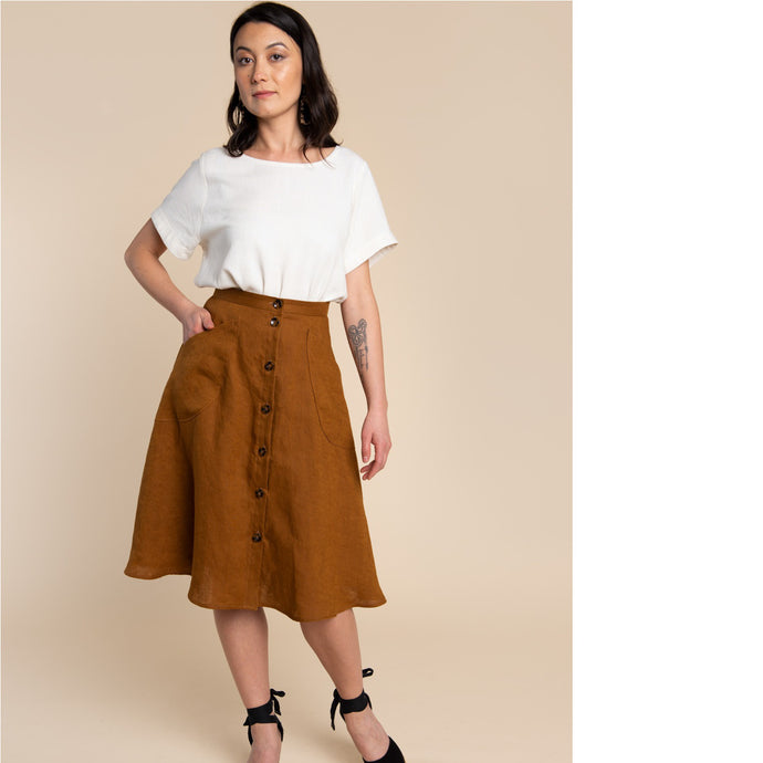 Lady wears Fiore Skirt, below-knee flare skirt with button front, and curved patch pockets