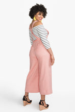 Load image into Gallery viewer, Side back view of lady wearing Jenny overalls with cross over straps at back
