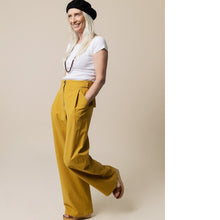 Load image into Gallery viewer, Lady wears wide-legged Mitchell Trousers, with hands in slanted side pocket
