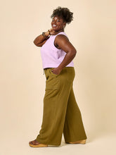 Load image into Gallery viewer, Side profile of model wearing wide leg trousers with large patch pockets and drawstring paperbag waist
