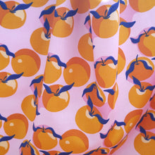 Load image into Gallery viewer, Organic cotton fabric with print of Clementines hangs showing drape
