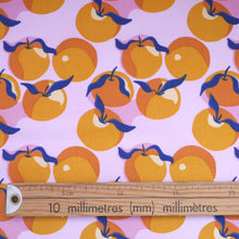 Load image into Gallery viewer, Close up of organic cotton fabric with print of Clementines shown next to a wooden ruler
